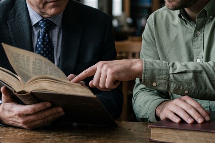 Pastor discipulando a un joven con la Biblia abierta